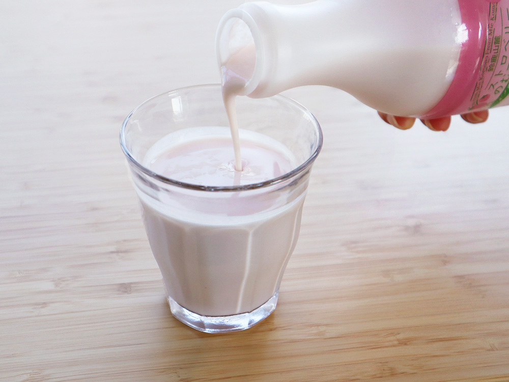 『鈴鹿山麓ストロベリーのむヨーグルト』を注いでいる