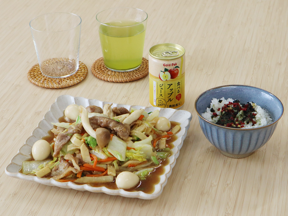 アイチョイスの商品を試食する様子の写真。 テーブルの上には、食材セット（ミールキット）の『白菜と豚肉のうま煮』、『本物茶葉のお茶漬け 梅干入』、『食べるアップルジュース』が食器に盛りつけられた状態で並べられている。