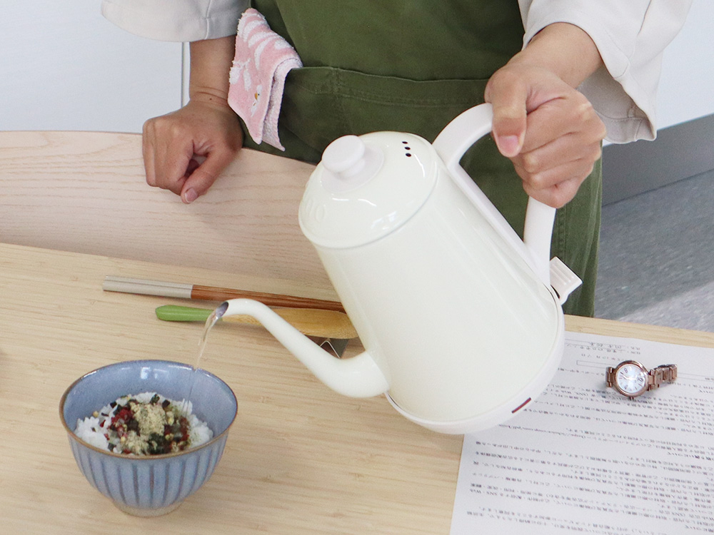 アイチョイスの商品である「本物茶葉のお茶漬け 梅干入」にお湯を注いで調理している様子の写真