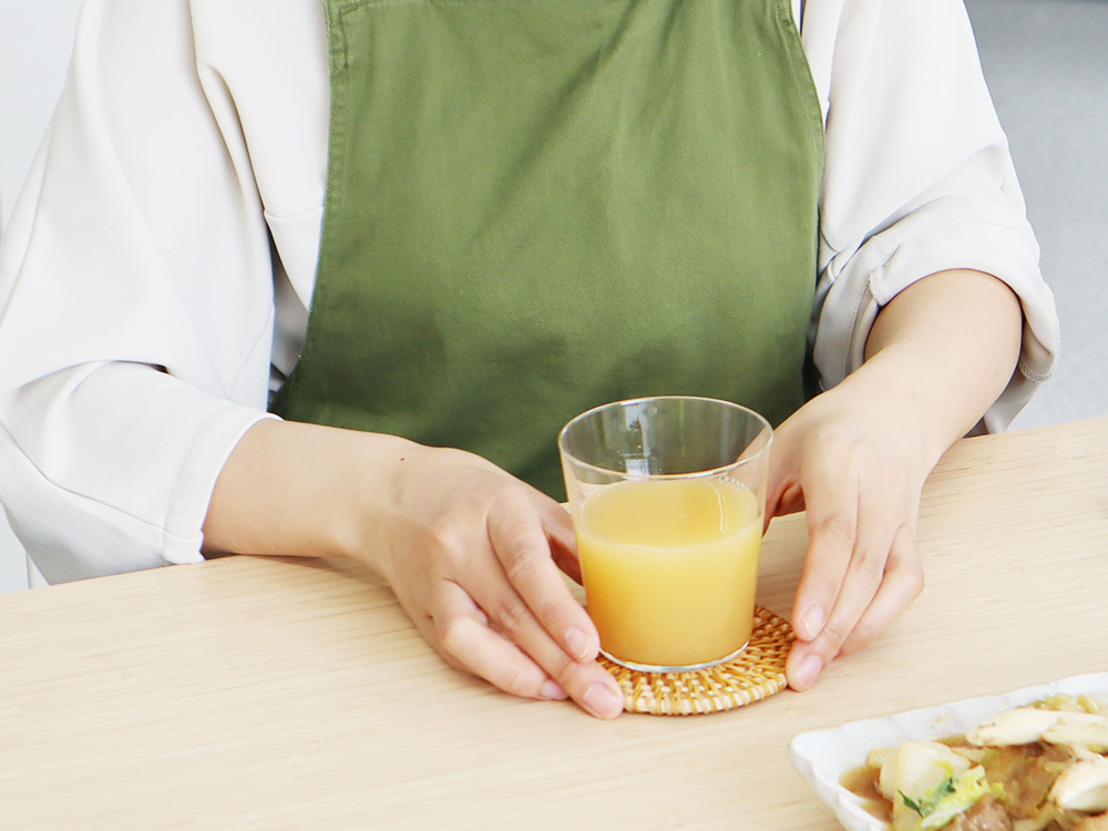 アイチョイスの商品である「食べるアップルジュース」を試飲している様子の写真