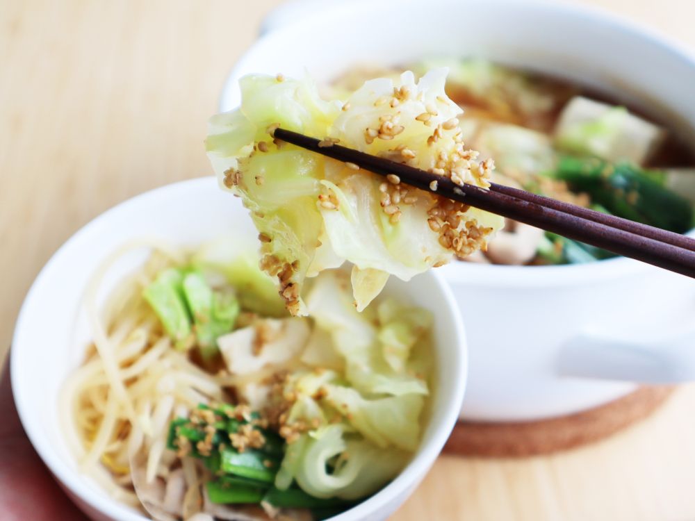 ごまがついたキャベツを箸で持ち上げている写真