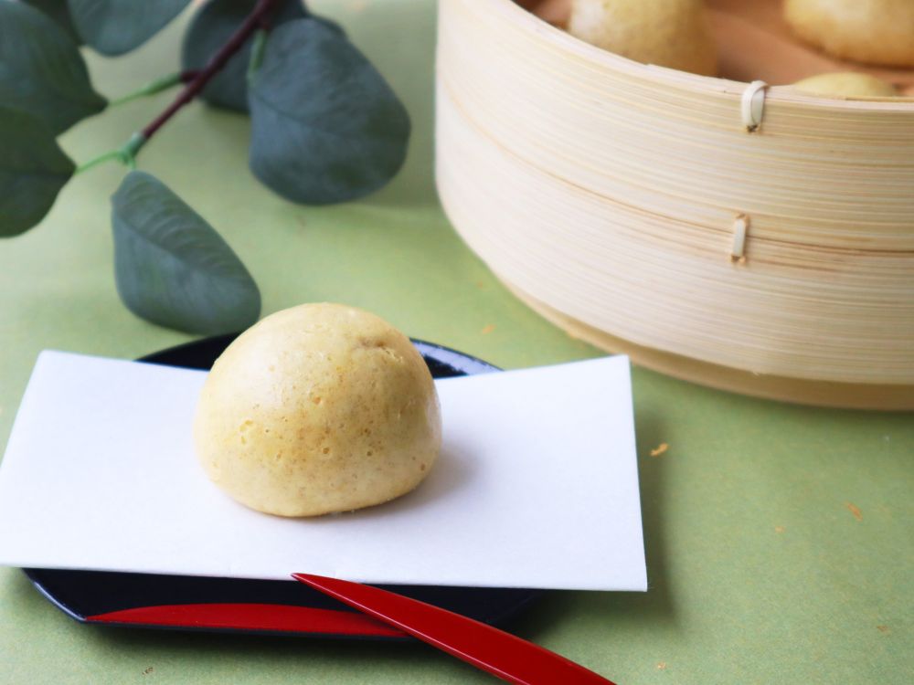 蒸籠と、皿の上にのったしょうがまんじゅうの写真