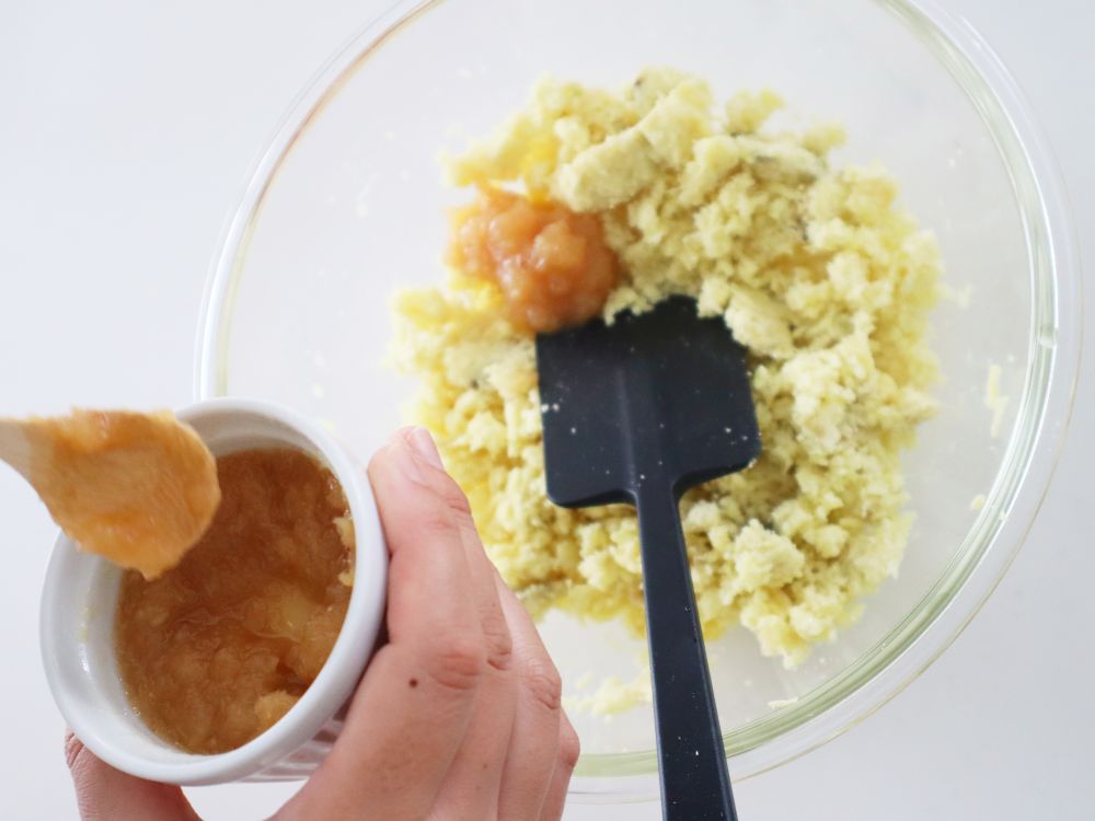 つぶしたさつまいもが入ったボールに、しょうがジャムを加えている様子