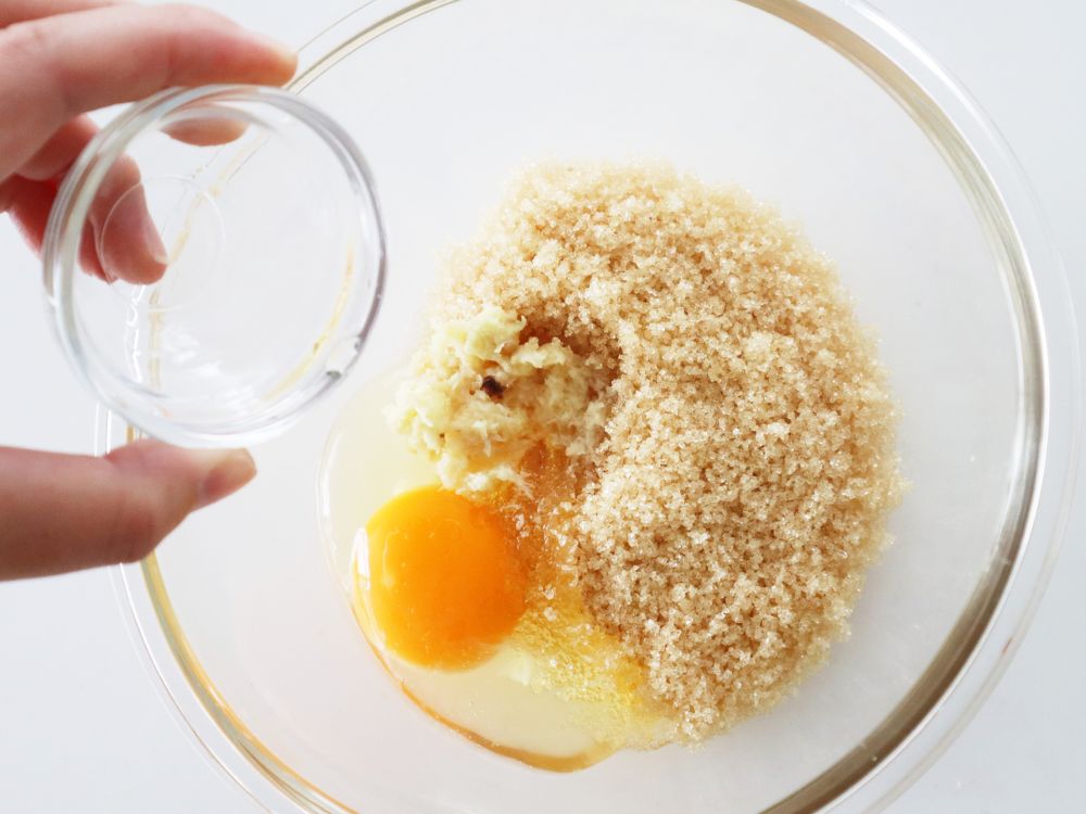 ボウルに砂糖、卵などの材料を入れている様子