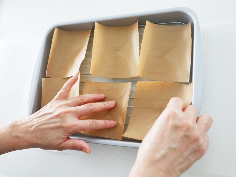 バットにカットしたクッキングシートを並べている様子