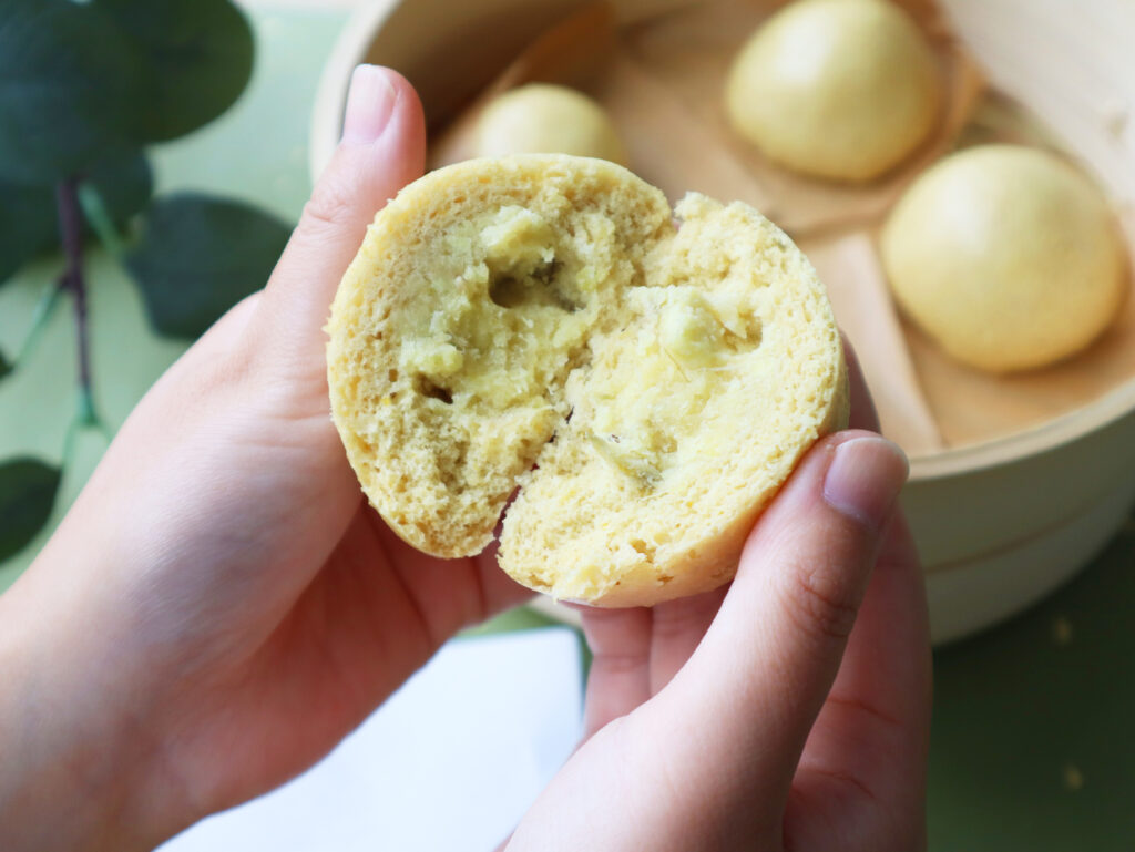 しょうがまんじゅうを手で持って半分に割っている様子