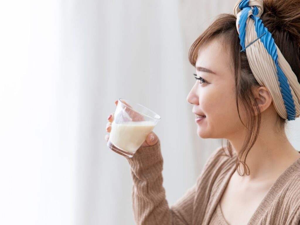 アーモンドミルクを飲む女性