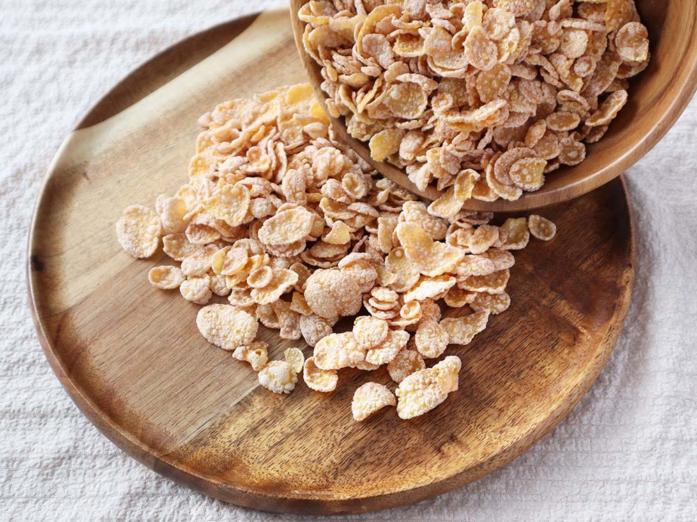 木製のさらに流し込まれるコーンフレーク