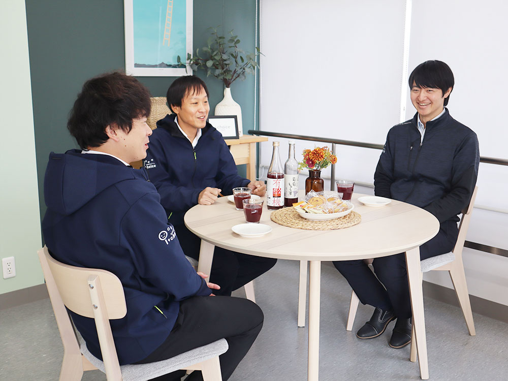 食卓で談話する男性職員3人