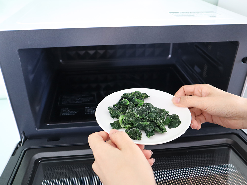 冷凍のほうれん草を電子レンジで解凍する様子