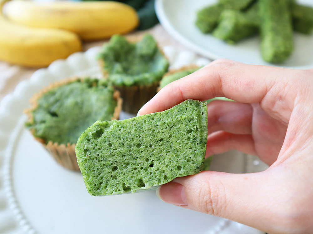 カットして断面の見えるほうれん草蒸しパンを持ち上げている様子