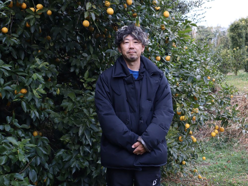 レモンの木の前に立つ伊藤さんの写真