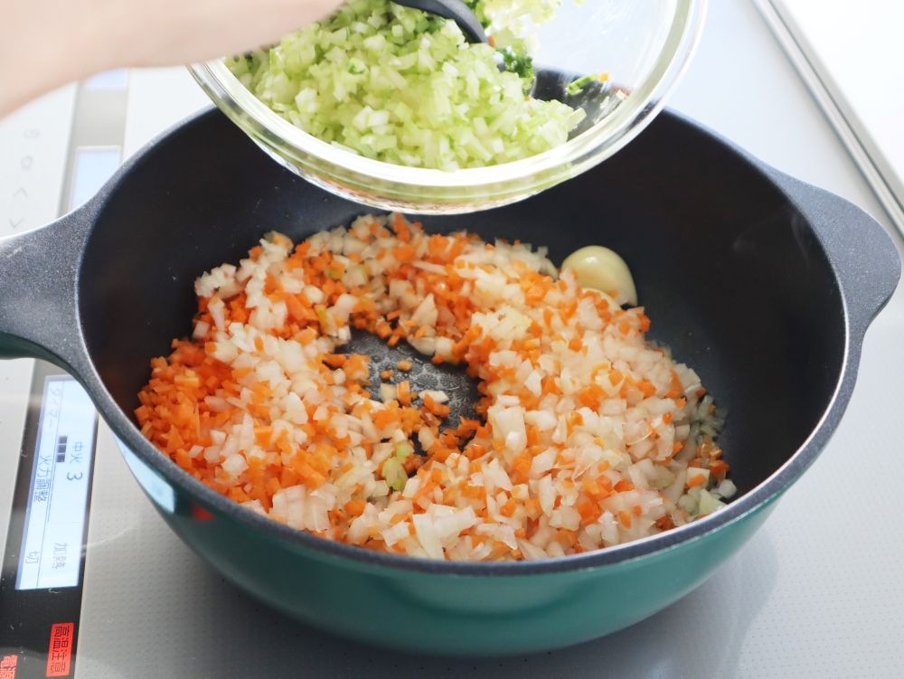 フライパンにみじん切りした野菜を加えているところ