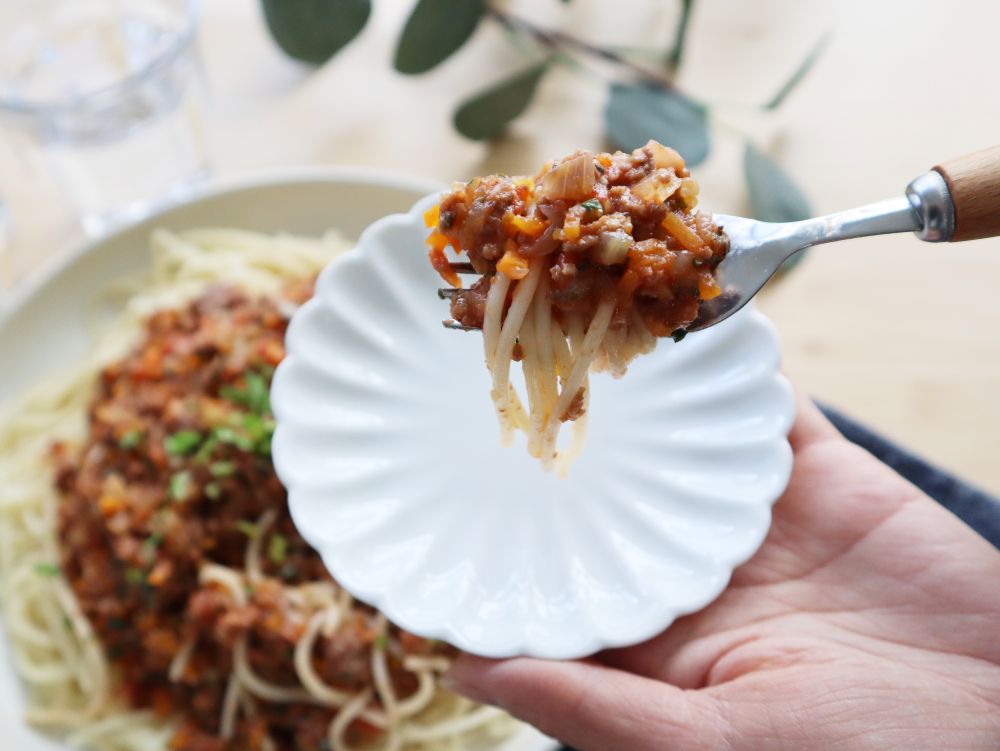 ミートソースパスタをフォークで取ってアップにした写真