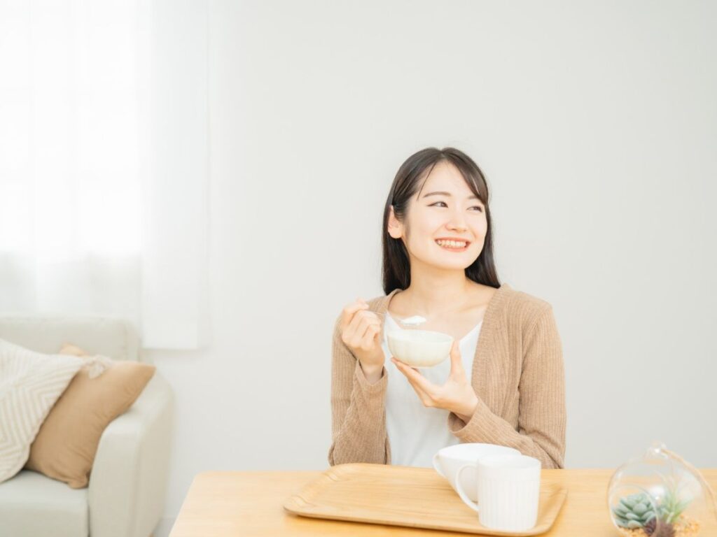 女性がヨーグルトを食べている写真