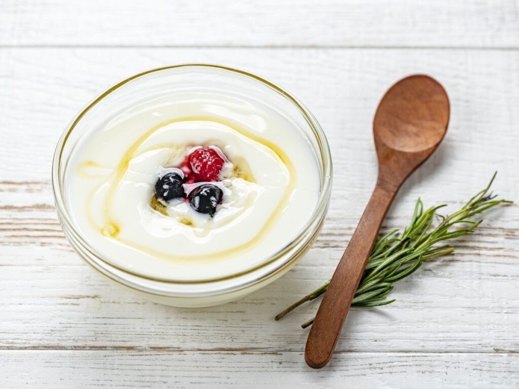 小皿に盛られたヨーグルトと木のスプーン