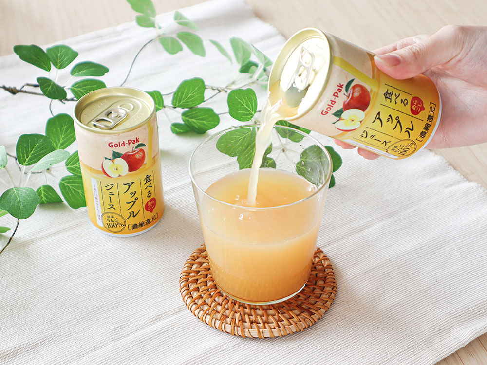 ゴールドパックの商品である『食べるアップルジュース』をコップに注いでいる最中の写真。