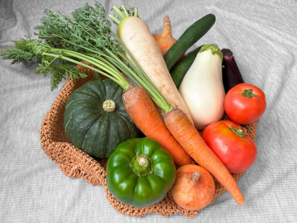 麻袋にかぼちゃやにんじん　大根　トマト　なす　きゅうり　ピーマンなどが入っている