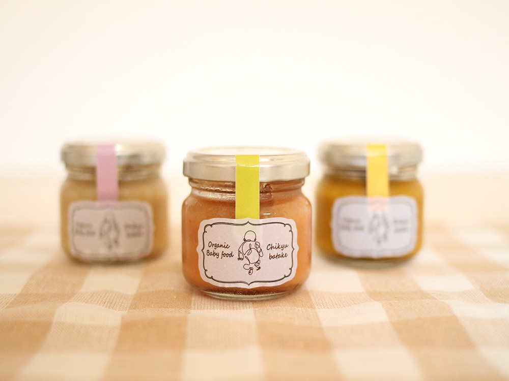 クロスの敷かれたテーブルに有機野菜ペーストの瓶が3つ並んでいる。