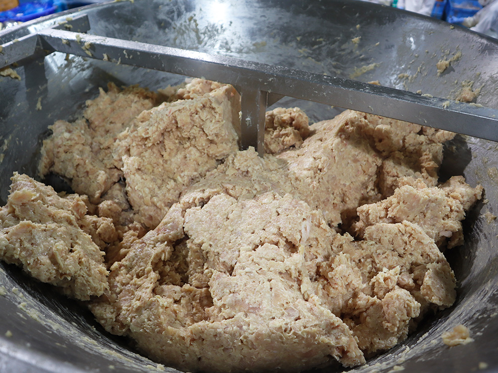 ミンチ機の中で鶏肉が練りこまれている写真