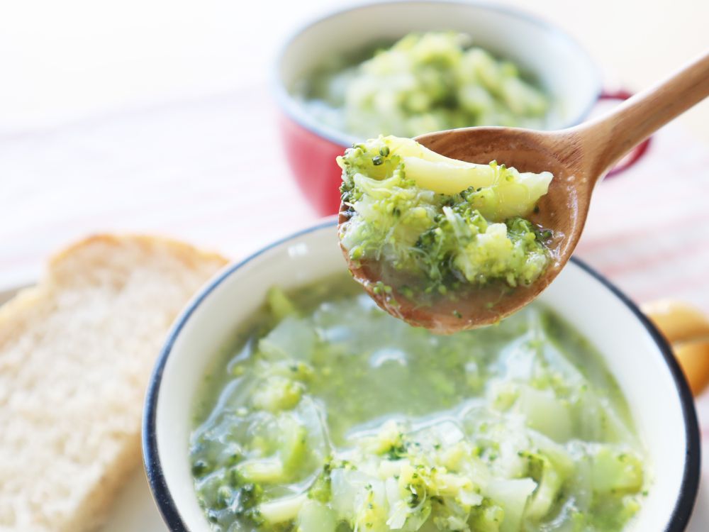 器に入った「ブロッコリーと玉ねぎのシンプルポタージュ」をスプーンで持ち上げている様子