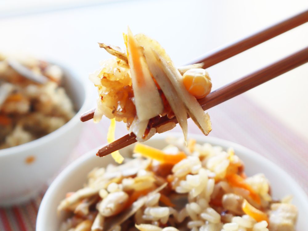 ごぼうと炒り大豆の炊き込みご飯を箸で持ち上げている様子