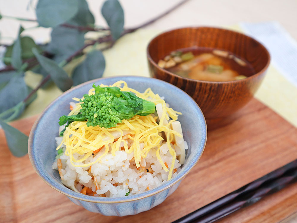菜花と筍の炊き込みご飯が汁物と一緒に配膳されている様子