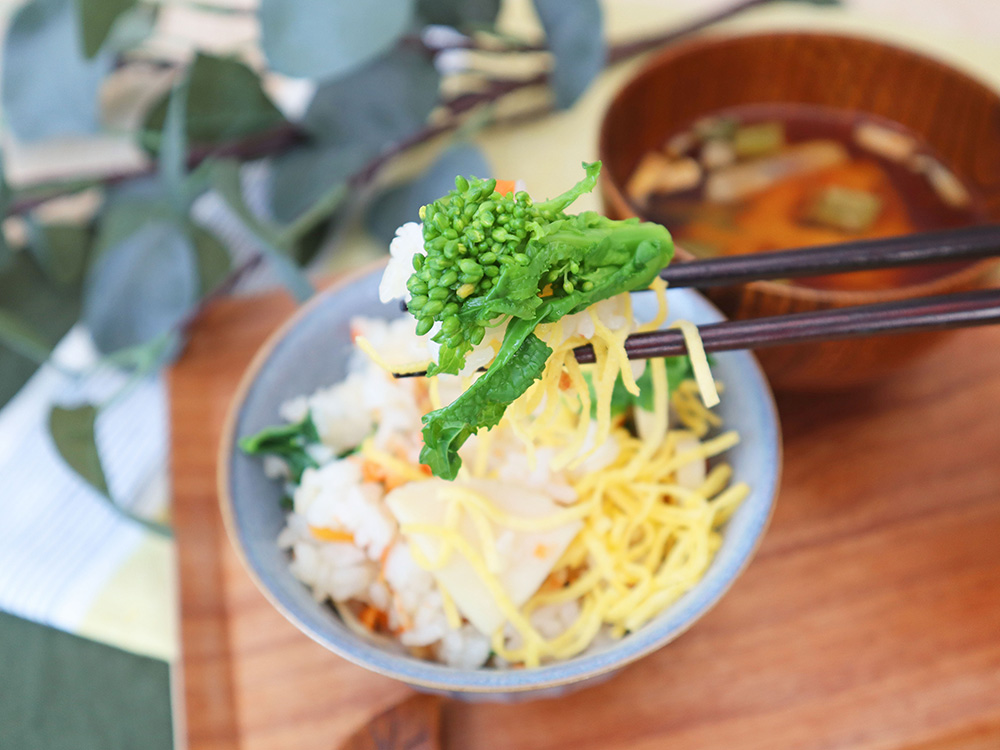 菜花と筍の炊き込みご飯を茶碗から箸上げするシーン