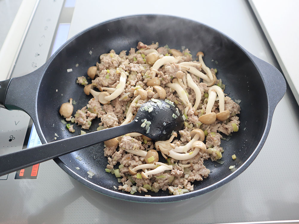 小松菜マーボー豆腐の調理工程でしめじやひき肉を炒めているシーン