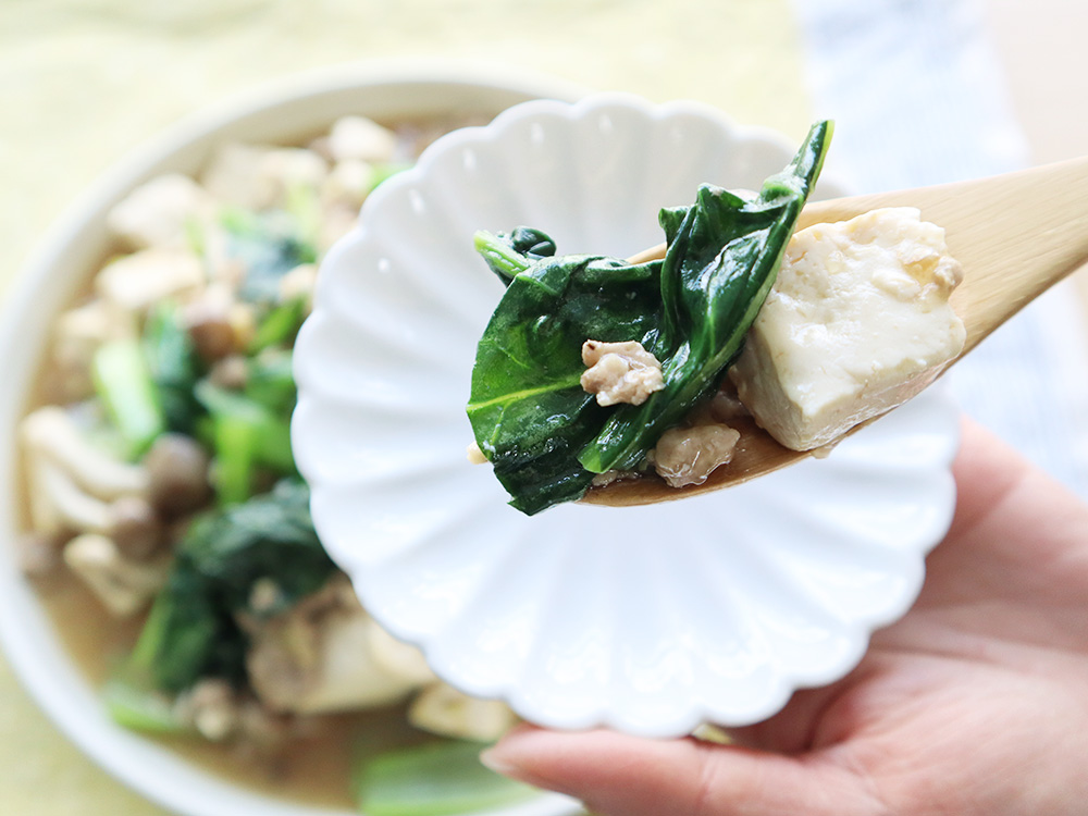 小松菜のマーボー豆腐を小皿に取って箸あげしている様子