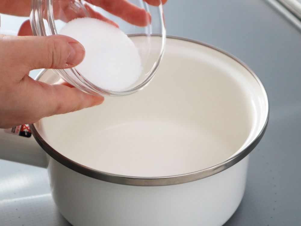 小鍋に砂糖をいれているところ