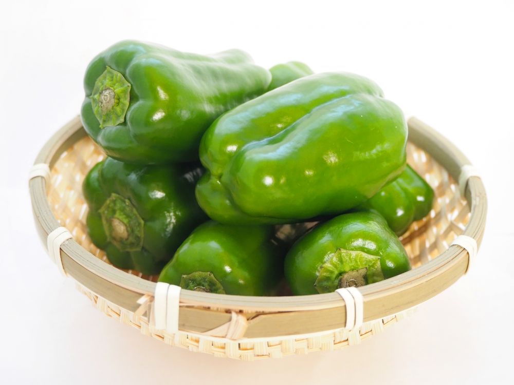 かごに盛られたピーマンの写真